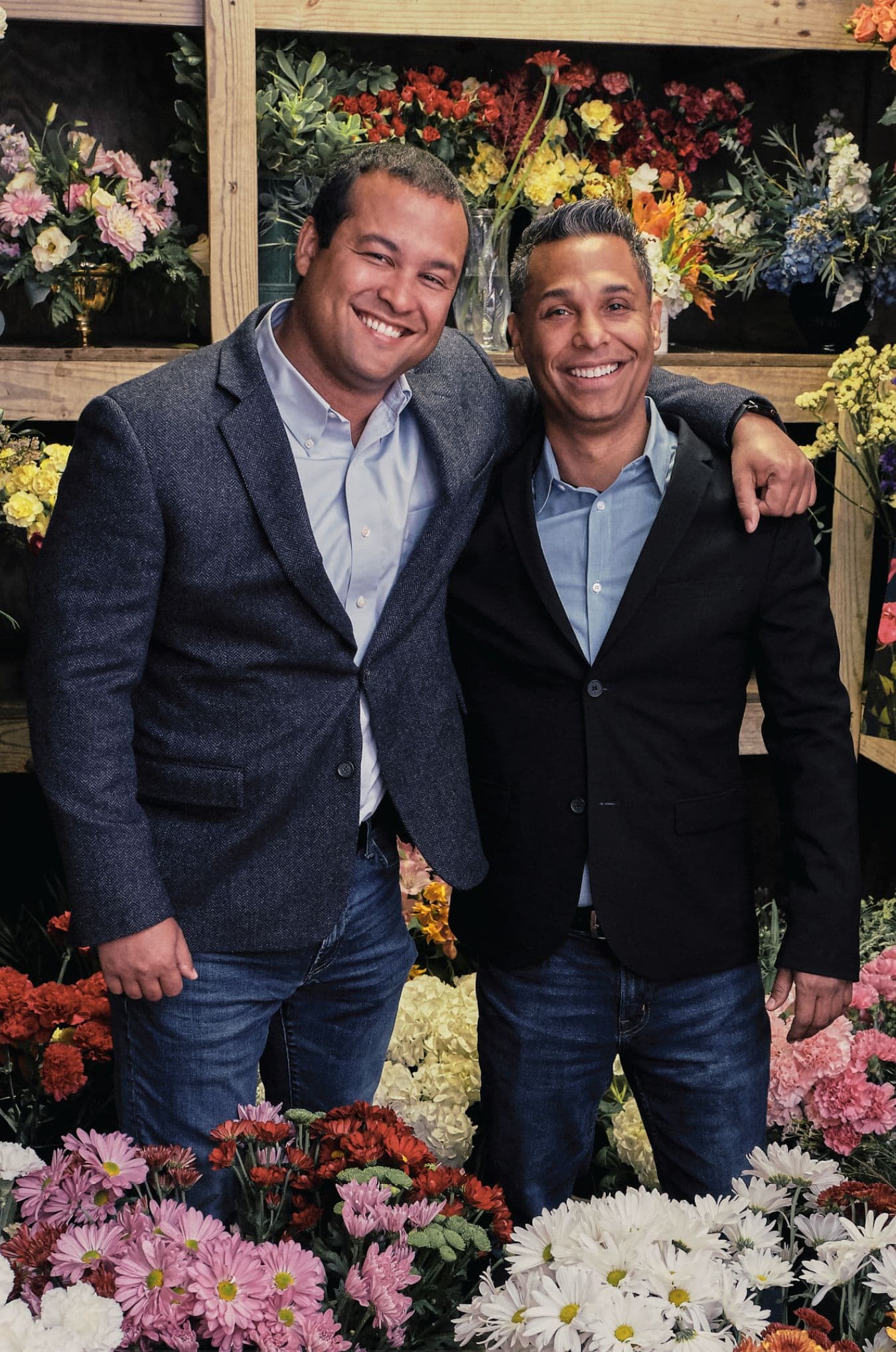 Lovingly CEO Joe Vega and CTO Ken Garland standing together among flowers.